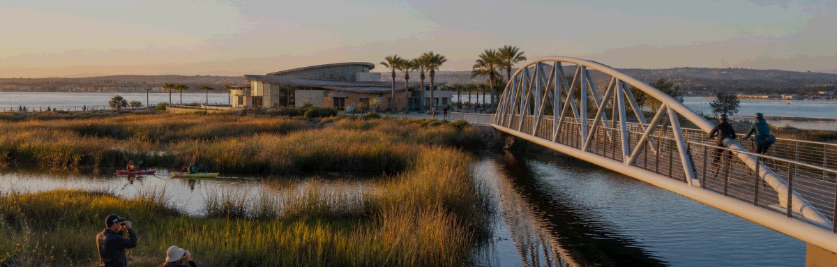 Bayfront wetlands and a pedestrian bridge on San Diego Bay at sunset